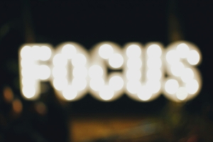 A slightly out of focus image of the word focus spelled in lights, like a writer grasping for focus as they try writing with distractions.